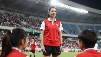 A 25-year-old female coach with a kind face, wearing a bright red jersey with white sleeves and a white collar, and black...