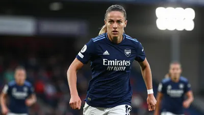 A 30-year-old, 5'9'' tall, female Arsenal Women midfielder, wearing a navy blue jersey with a smooth, unbroken fabric...