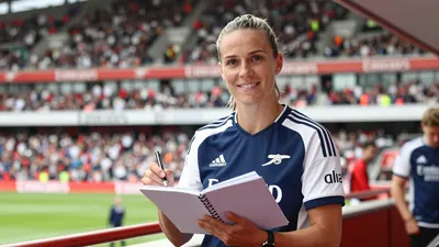 A photorealistic image of an anonymous Arsenal Women's staff member, aged 35-40, with a kind smile, holding a Block by...